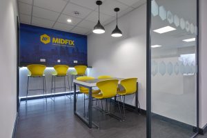 a breakout room with yellow chairs and a white wall